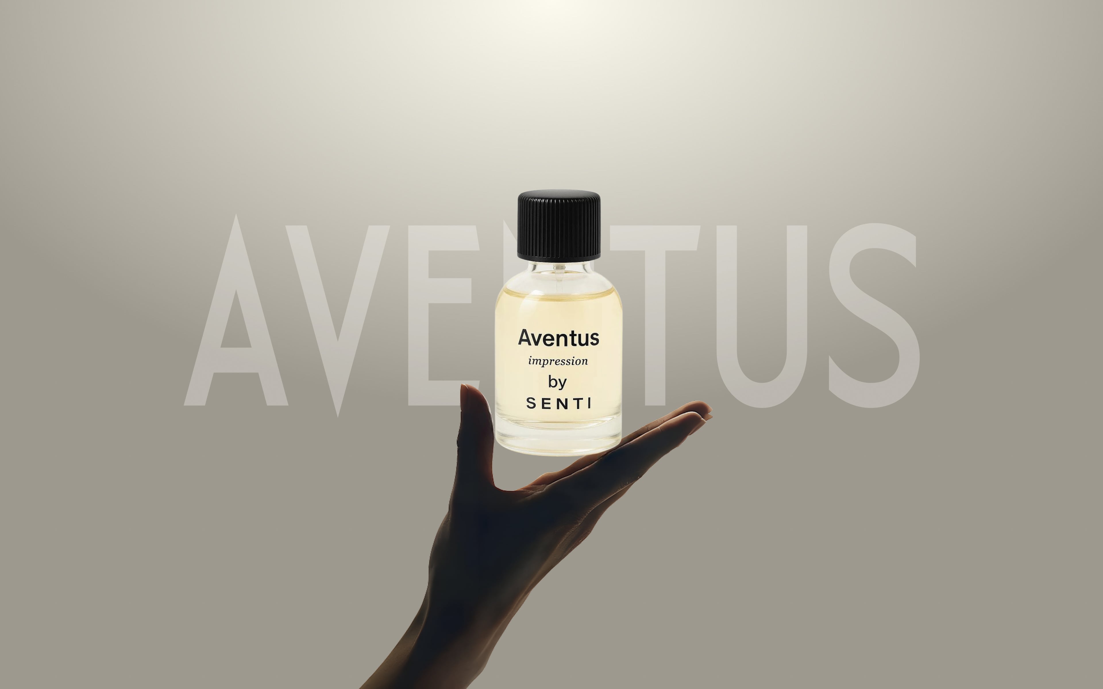 A hand delicately holding a clear glass bottle of Senti Aventus Impression perfume, with the word AVENTUS subtly visible in the background. Highlighting the signature fragrance.